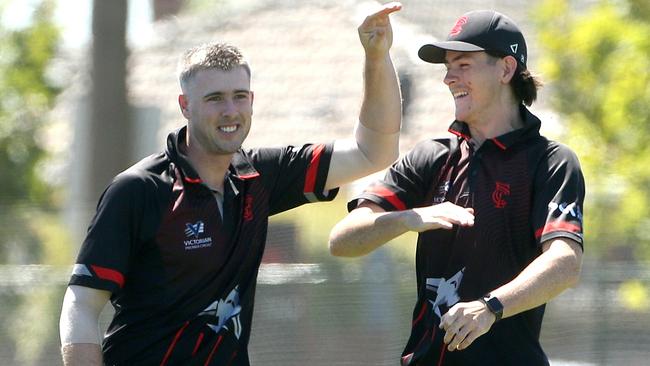 Tom O'Donnell and Cam McClure celebrate a wicket for Essendon. Picture: Hamish Blair