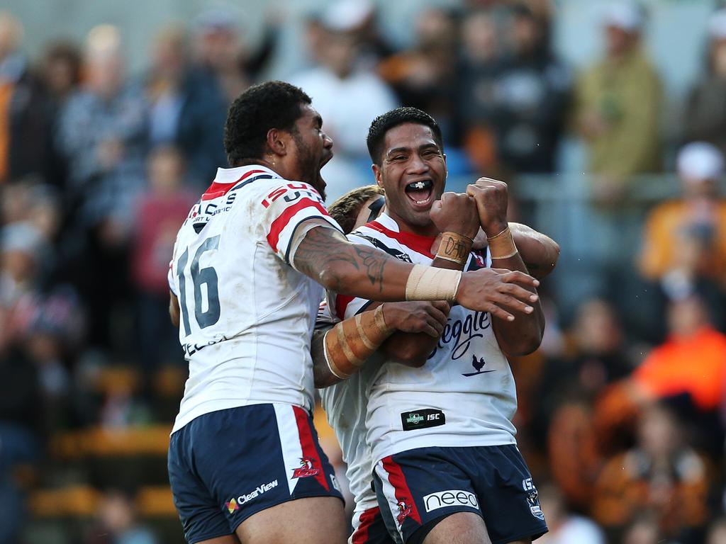 Lama Tasi (right) celebrates a try during his Roosters days.