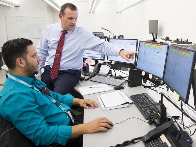 Cory Roeten, who runs the Operations Control Centre for driverless trains, speaks with traffic controller Heinz Bastiampillai, in Rouse Hill. Picture: Dylan Robinson