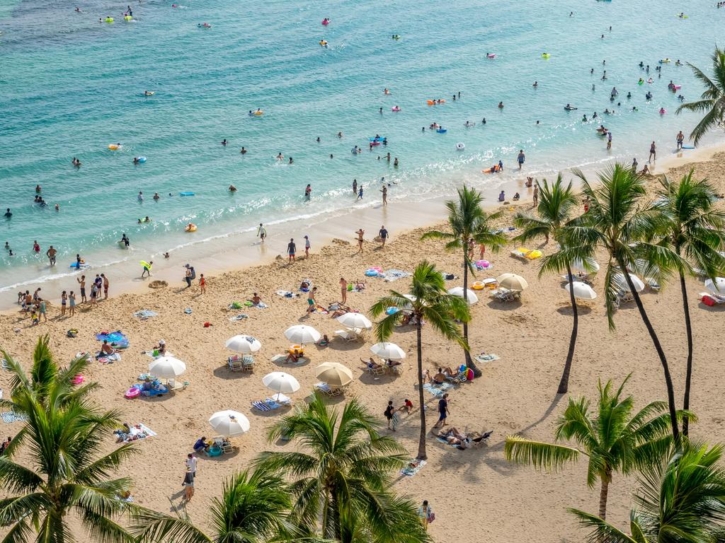 Sun lovers on iconic Waikiki beach in Honolulu. Climate change experts warn that the beach is under threat from rising sea levels. Picture: Supplied