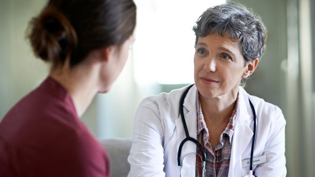 Shot of a compassionate doctor comforting a young woman in a hospital waiting room; fear health scare generic