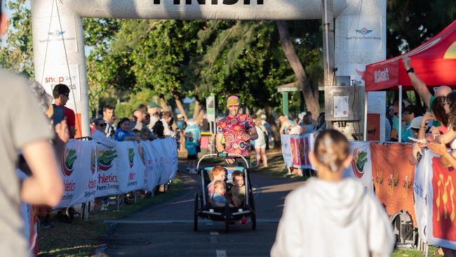 A father crossing the line after pushing his three children the full 12.5km. Picture: Pema Tamang Pakhrin.