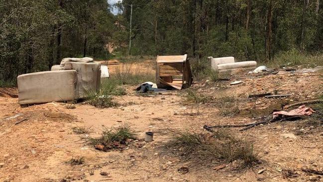 Illegal dumpers leave a trail of hard rubbish items through the woodland.