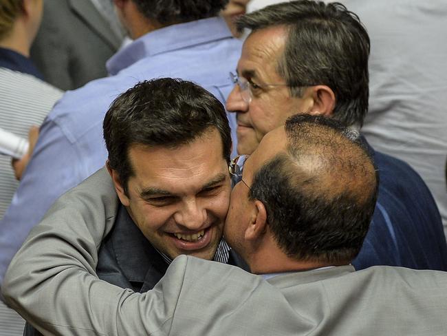 Smiling ... Greek Prime Minister Alexis Tsipras being congratulated by coalition members at the end of a session at the Greek Parliament in Athens.