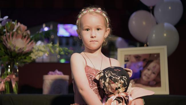 Brooklyn Fairfield (5) holds a bear made out of her mother's favourite dress at her memorial in Leanyer. Picture: (A)manda Parkinson