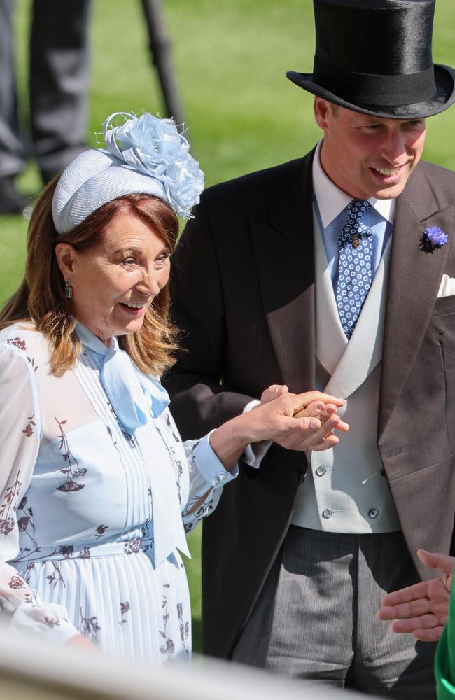 Carole Middleton holds hands with Prince William, Prince of Wales as they talk with a jockey. Picture: Getty Images