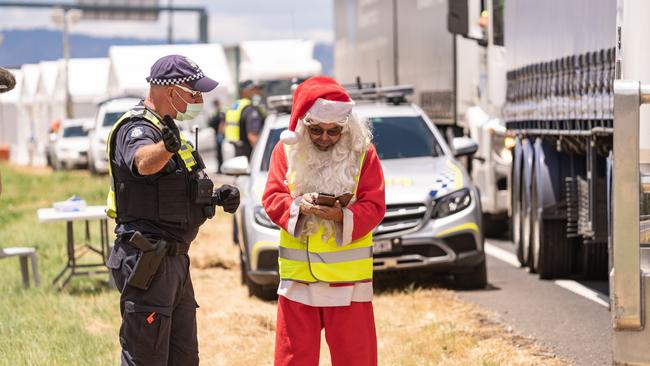 Santa the truck driver, aka Dean Elliott from Melton fills out his border pass at Wodonga. Picture: Simon Dallinger