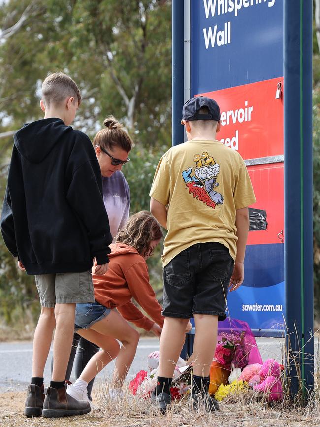 A family lays a tribute by a roadside sign at the Whispering Wall in the Barossa Valley. Picture: David Mariuz