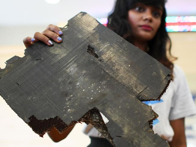 Grace Subathirai Nathan (R), daughter of Malaysian Airlines flight MH370 passenger Anne Daisy, shows a piece of debris believed to be from flight MH370 Picture: Mohd Rasfan, AFP