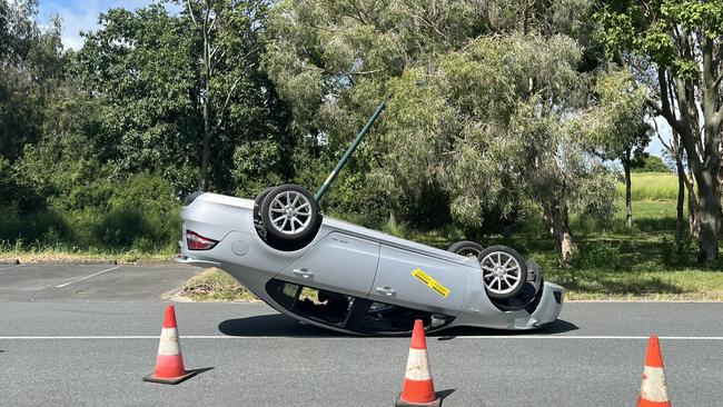 Car upside down after light pole crash