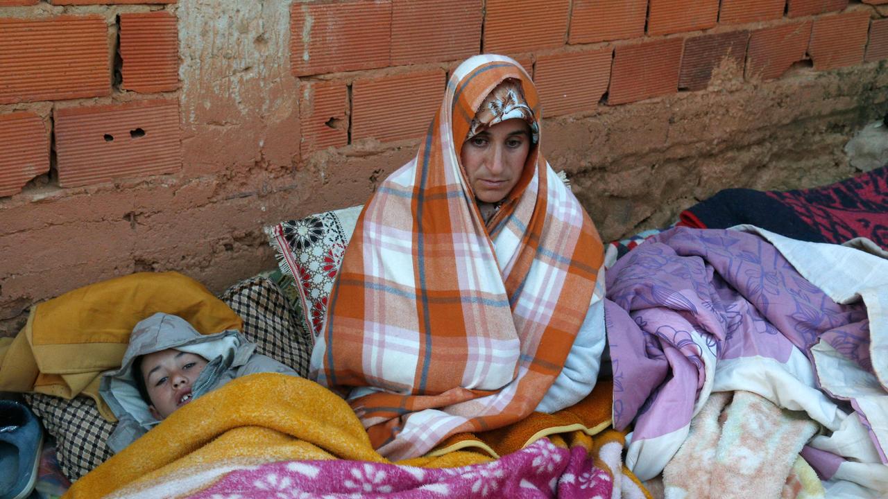 A Moroccan mother waits as authorities and firefighters work to get five-year-old child Rayan out of a well. (Photo by AFP)