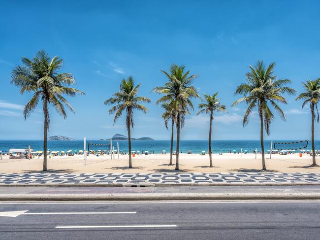 Palms on Ipanema Beach with blue sky, Rio de Janeiro, Brazil. Famous mosaic boardwalk in front of palms. Picture: iStockDoc Holiday, Escape