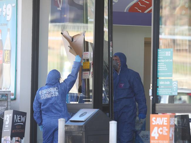 Forensic officers at the crime scene where “IS” was written with blood on a wall.