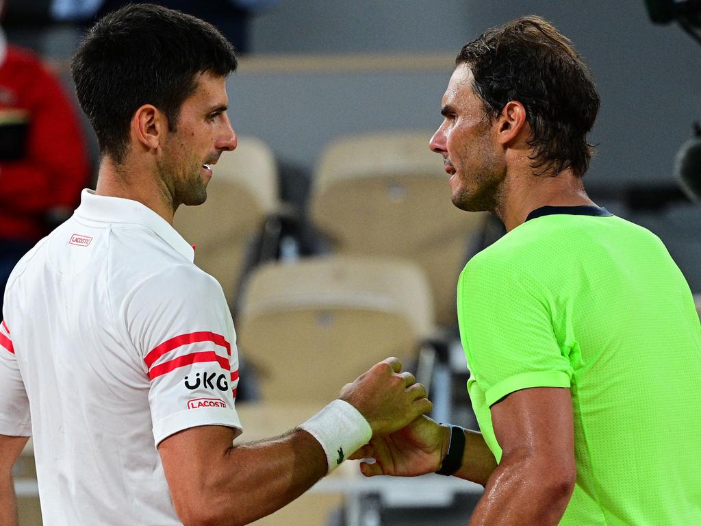 Novak Djokovic and Rafael Nadal shake hands at the end of their men's singles semi-final at the 2021 French Open. (Photo by MARTIN BUREAU / AFP)