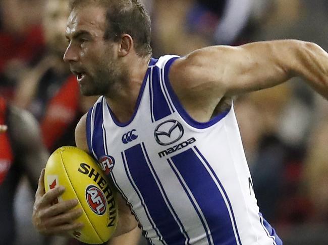 MELBOURNE, AUSTRALIA - MAY 23: Ben Cunnington of the Kangaroos evaders a tackle during the round 10 AFL match between the Essendon Bombers and the North Melbourne Kangaroos at Marvel Stadium on May 23, 2021 in Melbourne, Australia. (Photo by Darrian Traynor/Getty Images)