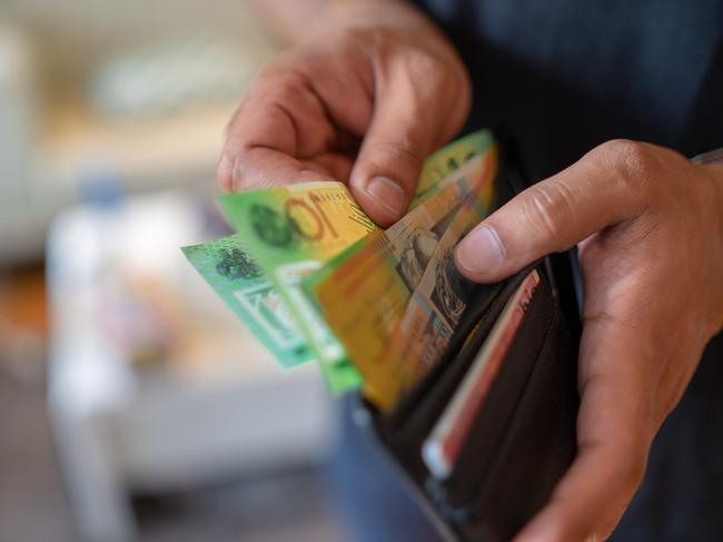 a male taking money out of a wallet, Australian cash generic spending