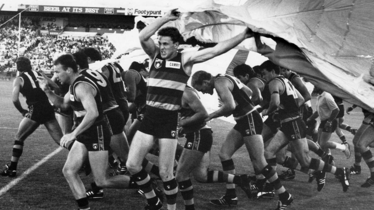 Adelaide Crows players burst through a banner for the first time on February 1, 1991, at the club’s first trial match, against Essendon at Football Park. Picture: Neon Martin.