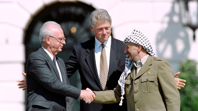 US President Bill Clinton stands between PLO leader Yasser Arafat, right and Israeli Prime Minister Yitzahk Rabin, left as they shake hands in 1993 at the White House. Picture: AFP