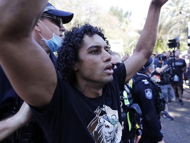 Police with a protester at the rally. Picture: NCA NewsWire / Josh Woning