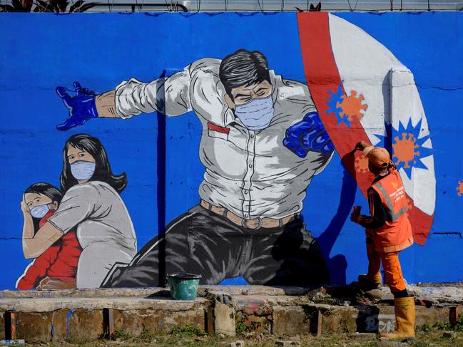 A Covid mural goes up in Jakarta on Thursday. Picture: AFP