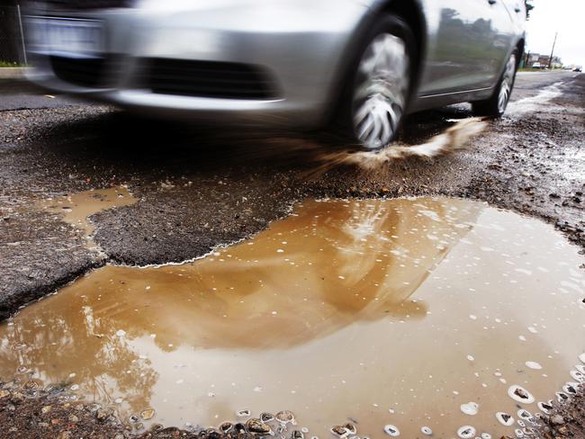 A large pothole filled with water on Fyfe Road, Kellyville Ridge in Sydney, one of Sydney's worst roads for potholes.