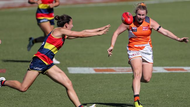 Tait Mackrill kicks the ball past Angela Foley. Picture: Matt Turner/AFL Photos via Getty Images.