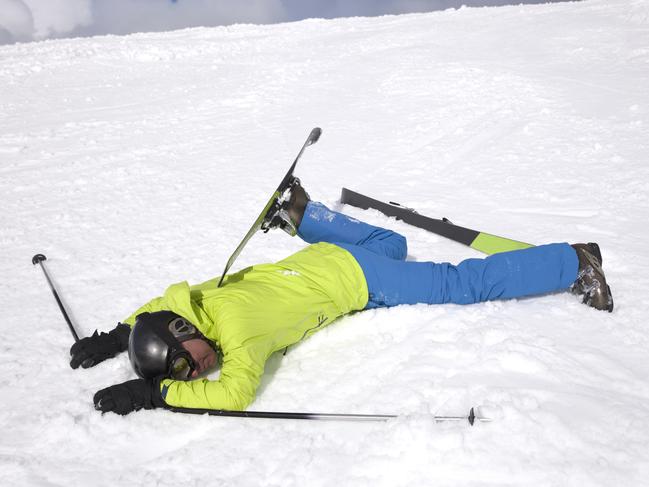 Male skier lying in the snow after an accident.