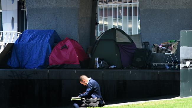 A business man sits in the sunshine at Enterprize Park, along the Yarra, where homeless have set up camp. Picture: Nicole Garmston