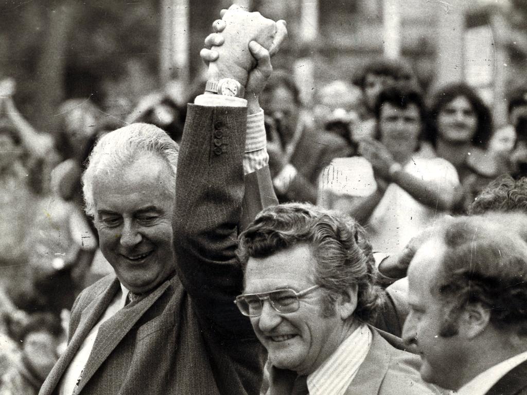 Gough Whitlam and Bob Hawke clasp hands in salute at ALP rally in 1975.