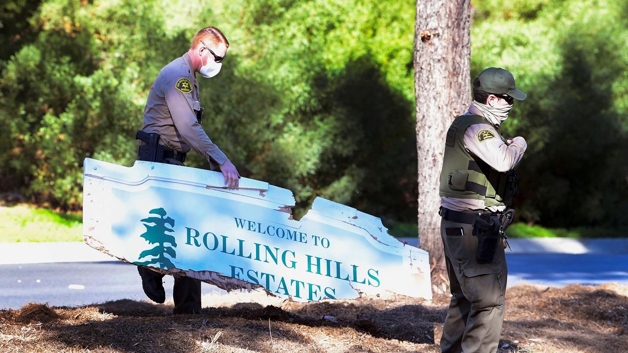 Police remove a damaged sign at the site of the crash. Picture: AFP