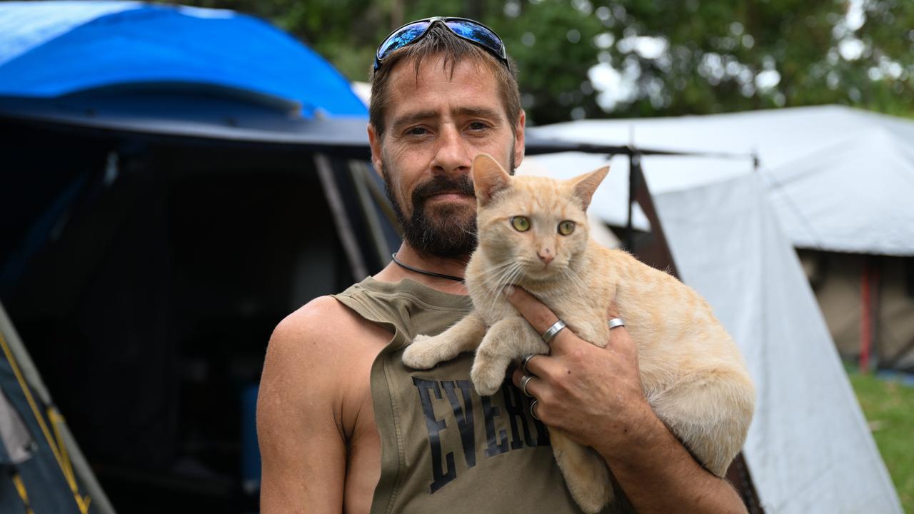 Zane McGill with his cat TahZan outside his tent at Mckillop Park in Rothwell, where he has lived for the past 12 months. The makeshift tent community is located in Queensland Premier Steven Miles’ own electorate of Murrumba. Picture: Dan Peled / NCA NewsWire