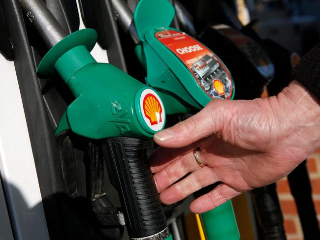 (FILES) In this file photo taken on January 20, 2016 a man reaches for an unleaded petrol nosel at a fuel pump outside a Royal Dutch Shell petrol station in Hook, near Basingstoke. - Faced with soaring inflation putting pressure on their budgets, Britons are cutting back on food and petrol, according to official retail sales figures released on April 22, 2022. Retail sales fell by 1.4% in March, accelerating the decline seen in February (-0.5%), although they remain slightly above their pre-pandemic level (Photo by Adrian DENNIS / AFP)