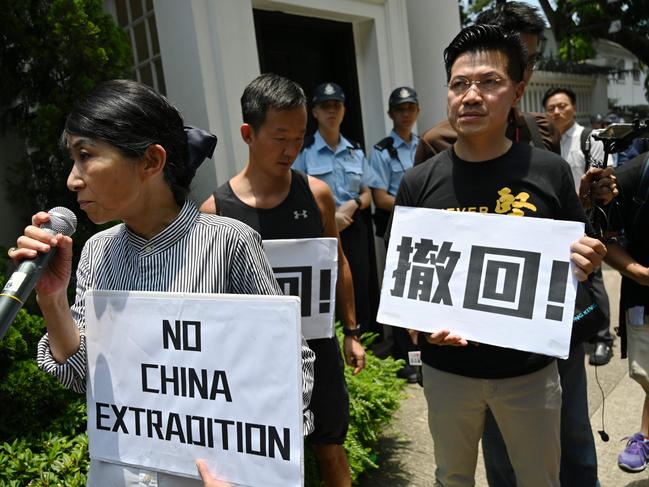 Demonstrators take a stand while police stand guard next to the Government House in Hong Kong. Picture: AFP