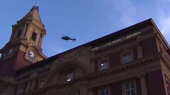 A police helicopter hovers over Auckland CBD. Picture: 1News