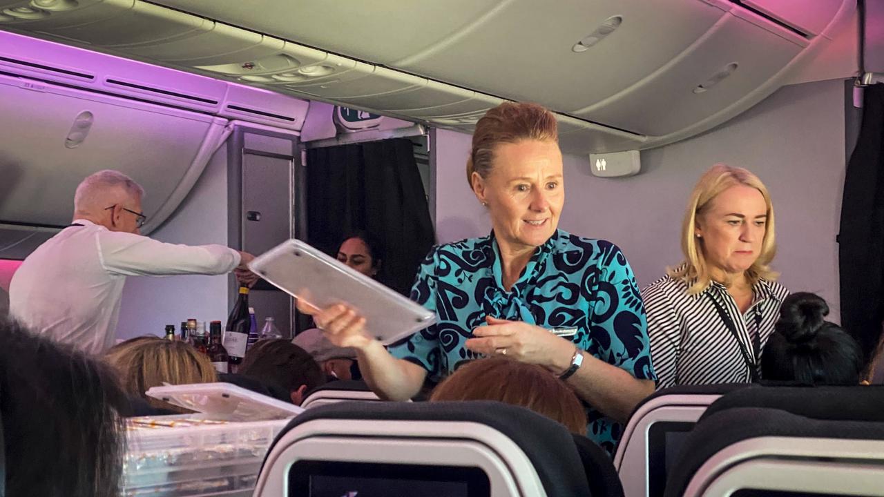 Dame Therese Walsh and CEO Greg Foran serving drinks on a flight to Tokyo that was diverted via Brisbane. Picture: NZ Herald