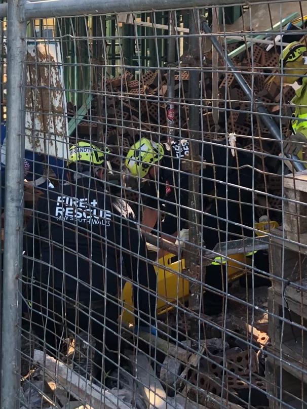 Firefighters worked to free a man who was trapped under rubble after a building collapsed. Picture: Fire and Rescue NSW