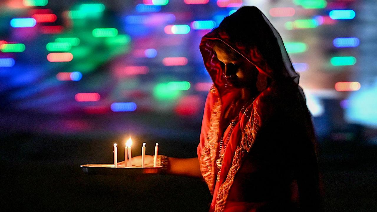 A woman lights candles in front of her house in New Delhi, India, during the celebrations to mark Diwali, the country’s biggest and most important holiday. Picture: Arun Sankar/AFP