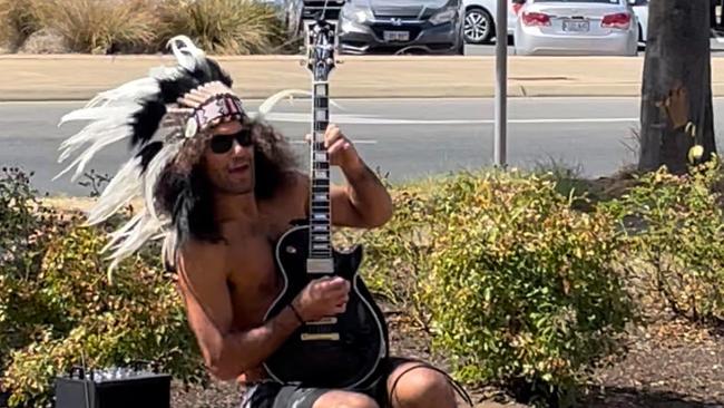 Savas Caruso plays guitar in front of the Elizabeth Magistrates Court in front of stunned onlookers. Picture Jason Katsaras