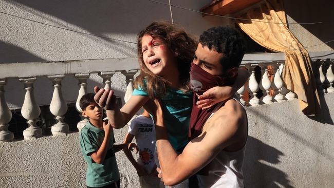 A man carries a rescued Palestinian girl from the rubble of a building after an Israeli air strike at the Rafah refugee camp, in the southern Gaza Strip on October 17. Picture: Said Khatib/AFP