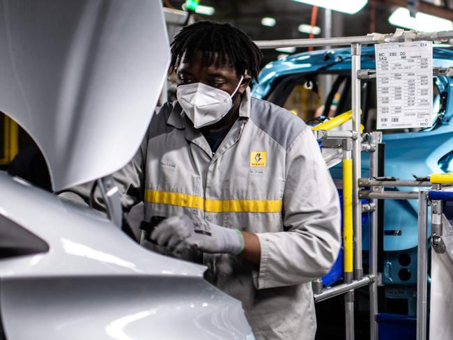 (FILES) In this file photo taken on May 6, 2020 employees wearing protective masks against the spread of the novel coronavirus, COVID-19, work along the assembly line that produces both the electric vehicle Renault Zoe and the hybrid vehicle Nissan Micra, at Flins-sur-Seine, the largest Renault production site in France. - A new electric R5, plans for Alpine and Renault sold at a higher price: the French manufacturer is due to unveil on January 14, 2021 its roadmap to face the revolution in the automobile sector. (Photo by Martin BUREAU / AFP)