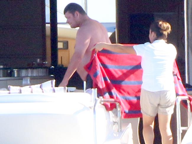 A woman holds ups a towel for James Packer aboard the Ganesh A, moored off the Baha Peninsula in Mexico last weekend. Picture: Clasos/splashnews.