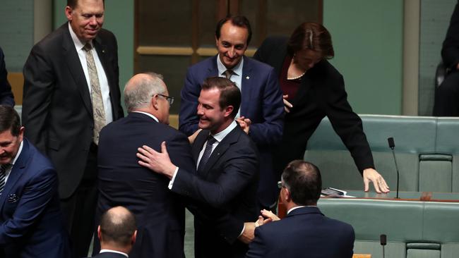 Prime Minister Scott Morrison moves in to give new Liberal MP James Stevens a man hug after his maiden speech. Picture Gary Ramage