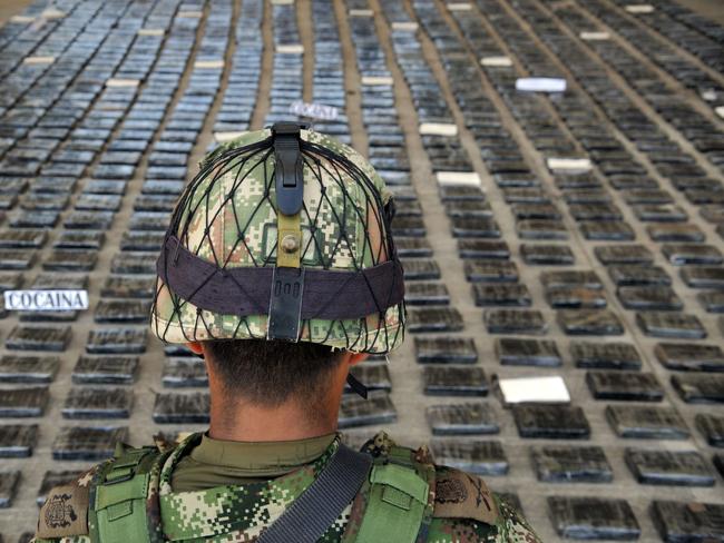 A soldier guards a shipment of 3.9 tons of cocaine seized in a large clandestine laboratory. Picture: AFP