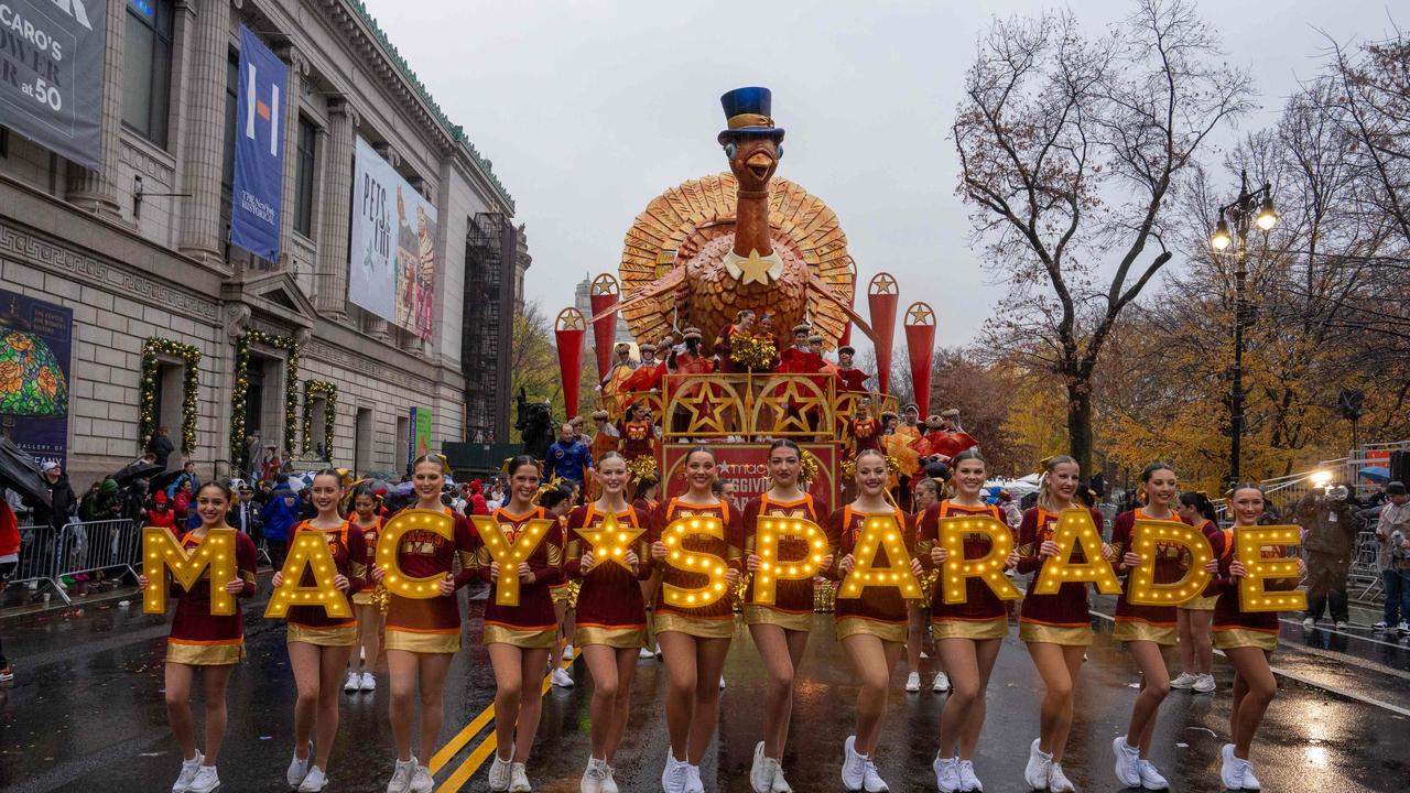 Cheerleaders perform in the rain in front of a large turkey. Picture: David Dee Delgado / AFP