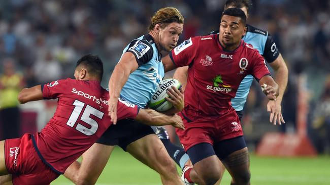 Waratahs captain Michael Hooper (C) is tackled by Reds defenders Karmichael Hunt (L) and Chris Feauai-Sautia (R) during the Super Rugby league match between the New South Wales Waratahs and the Queensland Reds in Sydney on February 27, 2016. AFP PHOTO / WILLIAM WEST --IMAGE RESTRICTED TO EDITORIAL USE - NO COMMERCIAL USE--