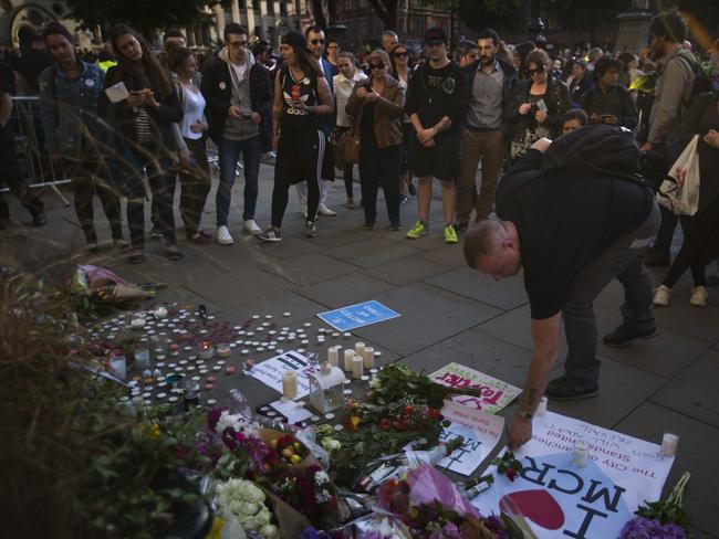 People lay flowers after a vigil in Albert Square, Manchester, England. Picture: AP