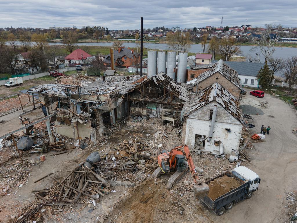 An excavator drops the debris in a truck outside the bread factory that was bombed during the Russian invasion west of Kyiv on April 19, 2022.
