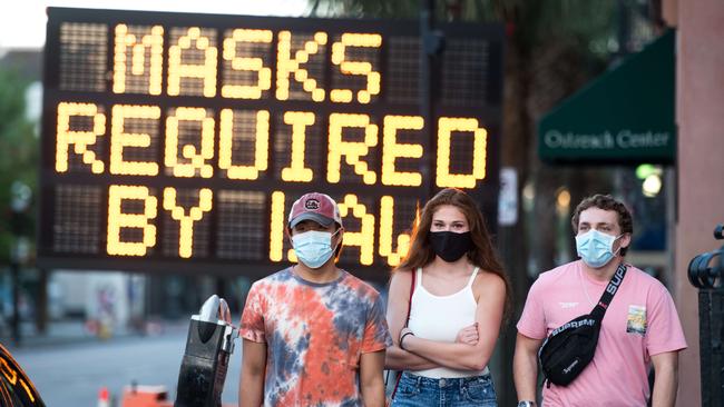 People wearing protective face masks walk along Charleston’s King Street in South Carolina. Picture: Getty Images