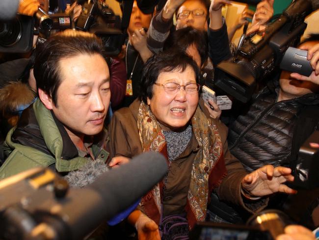 This picture taken on March 9, 2014 shows a relative (C) of a passenger who was travelling on board the missing Malaysia Airlines (MAS) flight MH370 reacting as she is escorted in a hotel in Beijing. China's state-run media on March 10 lashed out at Malaysia and its national carrier over their handling of the missing passenger jet, calling for a swifter response effort and tightened airport security.      CHINA OUT     AFP PHOTO (Photo by AFP)