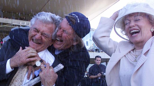 Owners including elated businessman John Singleton (C) hugs former PM Bob Hawke, watched by wife Blanche D'Alpuget, after victory by their racehorse Belle Du Jour, ridden by jockey Lenny Beasley in winning the 2000 Golden Slipper Stakes at Rosehill Racecoruse in Sydney.